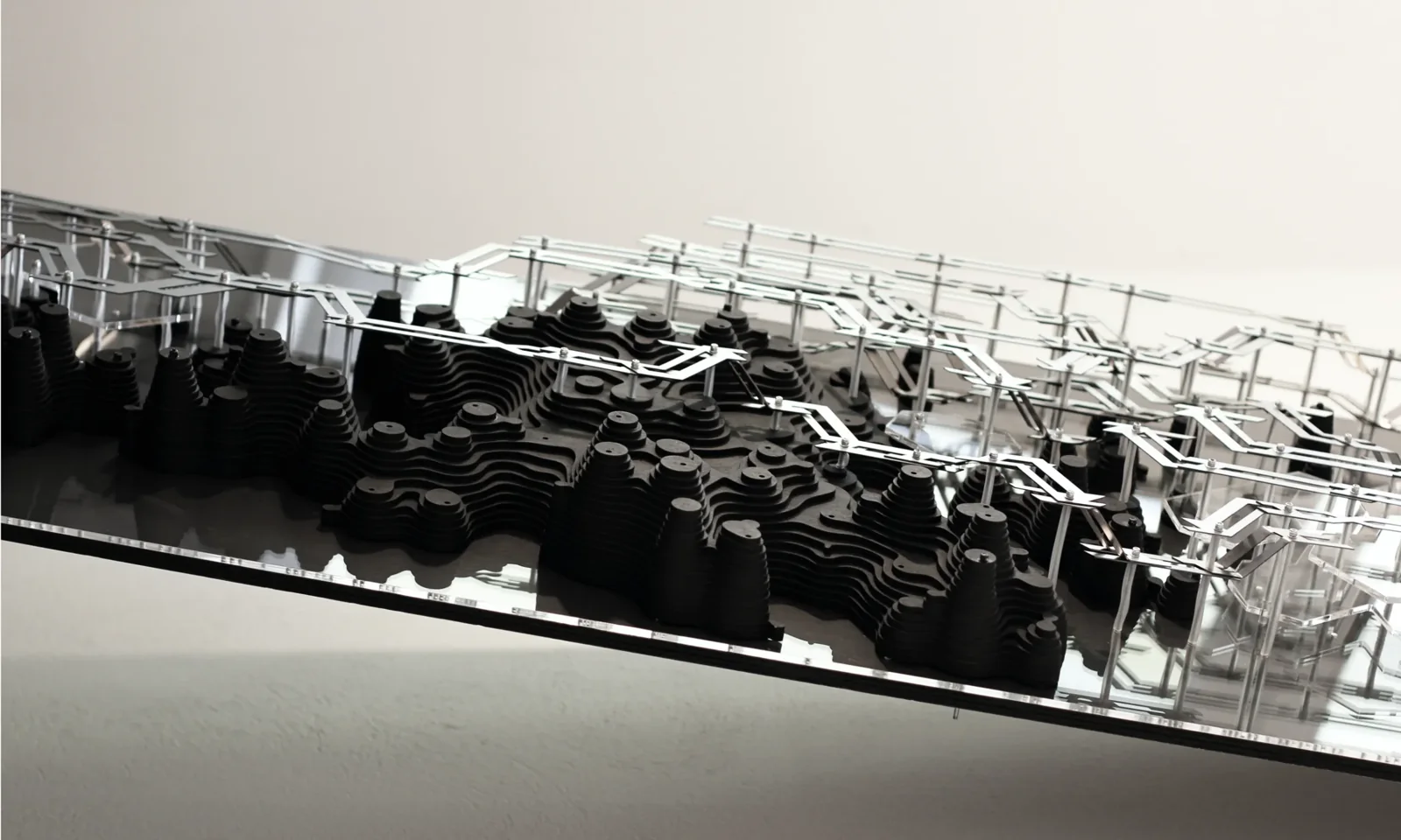 Side view of physical prototype showing layered plywood modules interwoven with metal connectors